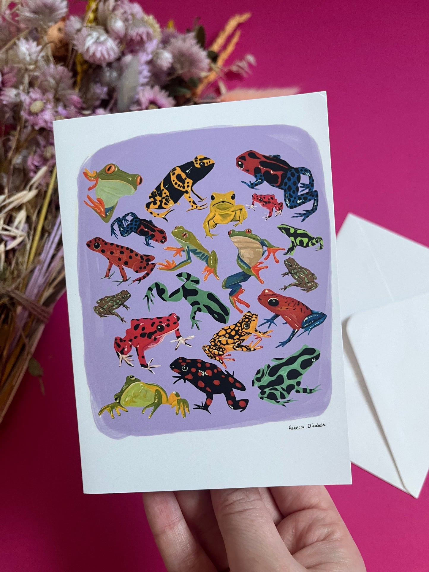 A collection of vibrant froggies to bring a pop of colour to your life. Hand painted rainforest frogs in gouache and edited digitally into a collaged design on a purple background with a pink back and the Rebecca Elizabeth Draws logo.