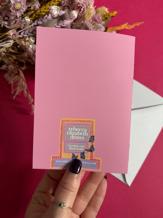 An illustration of a cute whimsical bookshop, the window shows the bookshelves inside full of bright coloured book spines with lots of flowers. The back of the card is pink with the Rebecca Elizabeth Draws logo.