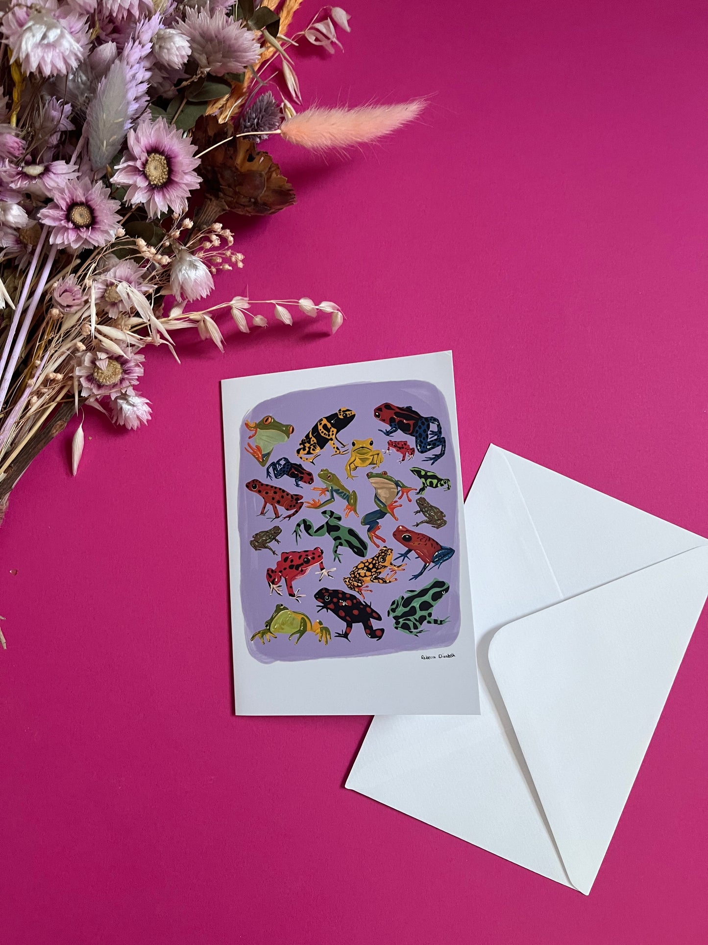 A collection of vibrant froggies to bring a pop of colour to your life. Hand painted rainforest frogs in gouache and edited digitally into a collaged design on a purple background with a pink back and the Rebecca Elizabeth Draws logo.