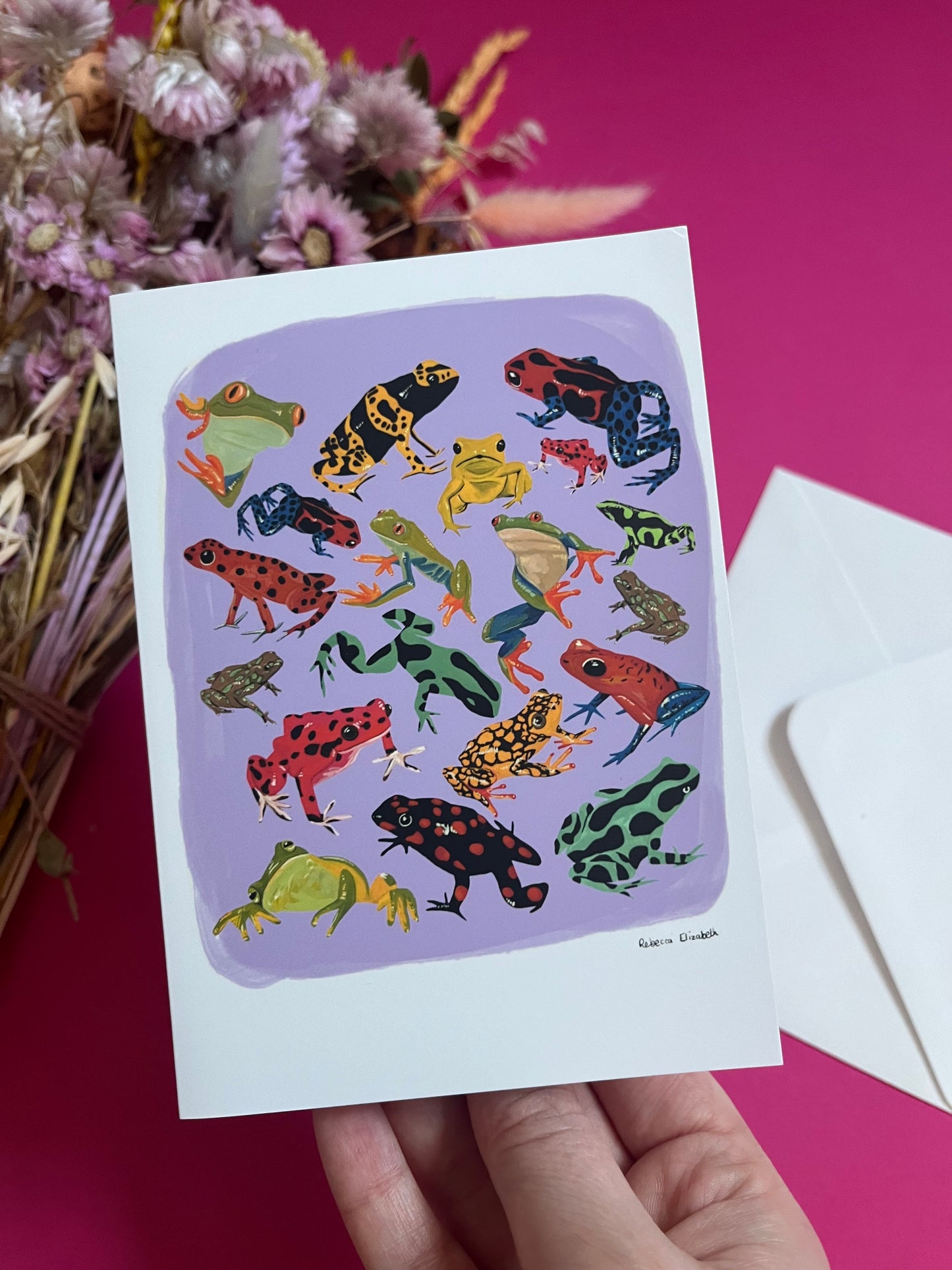 A collection of vibrant froggies to bring a pop of colour to your life. Hand painted rainforest frogs in gouache and edited digitally into a collaged design on a purple background with a pink back and the Rebecca Elizabeth Draws logo.