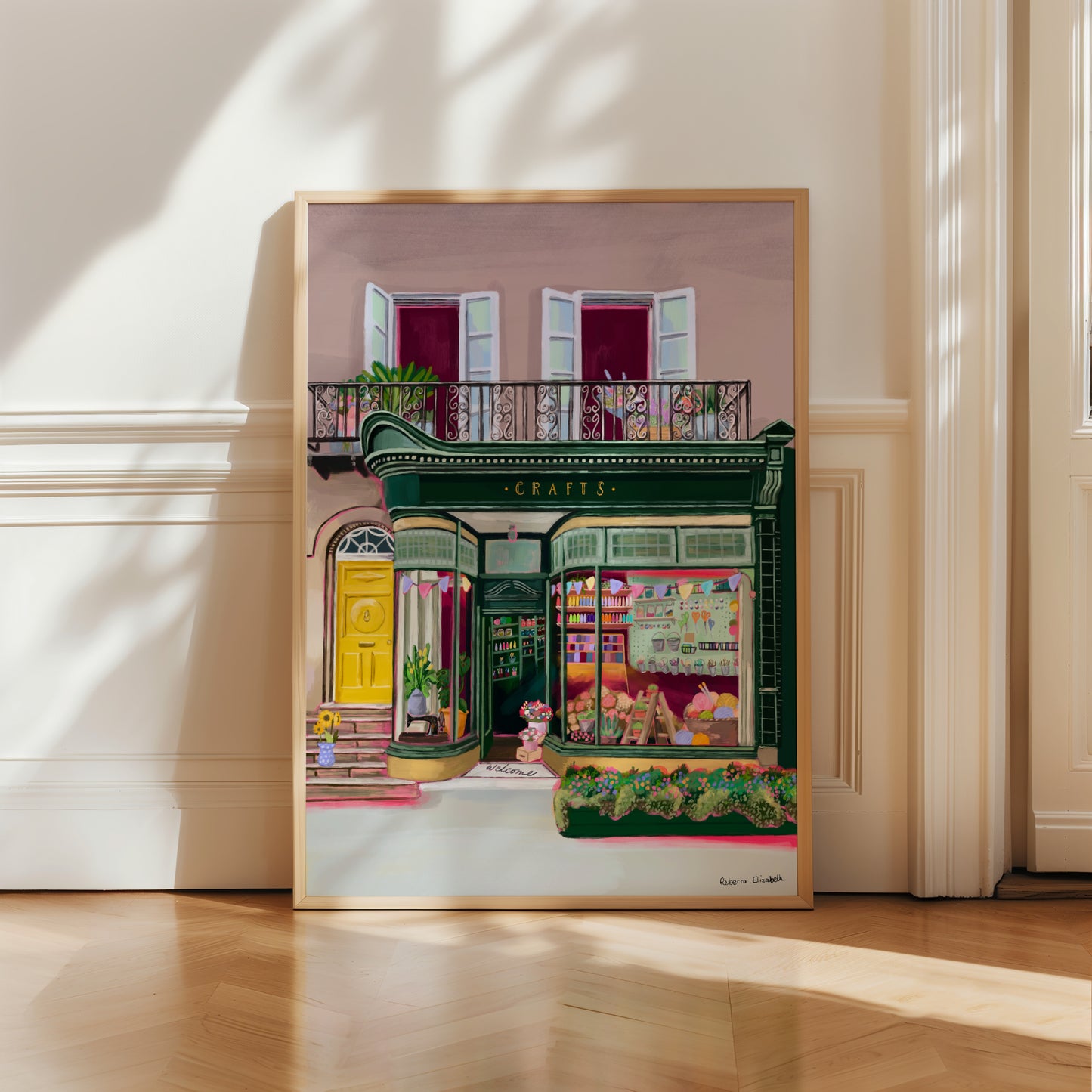 A colourful illustration of a craft shop with the store front in green and looking through the window and at all the goodies. Sewing, drawing, painting, we have it all here at the craft shop. Designed by Rebecca Elizabeth draws.