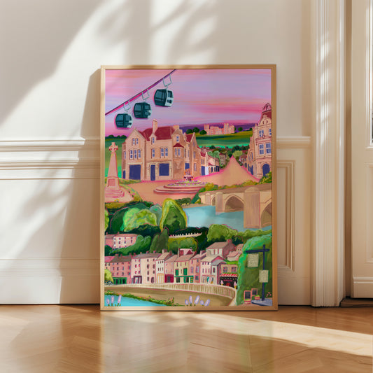 An illustration of Matlock bath and Matlock Derbyshire. Places included are the shops and amusement arcades of Matlock bath, the cable cars and the county offices of Matlock. The war memorial and Riber castle. All set against a pink and purple setting sun sky.