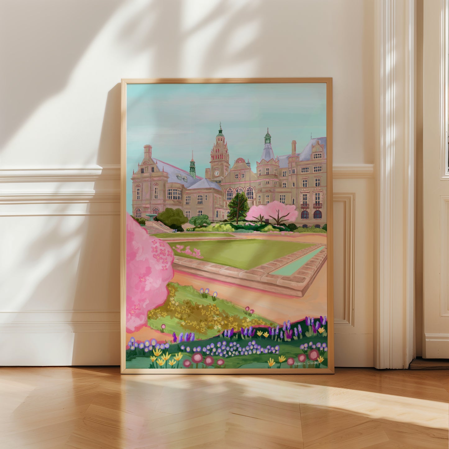 An illustration of the view of the Peace Gardens, Sheffield city centre in springtime. A soft brown building of Sheffield’s town hall with trees in front and pink blossom trees in soft pinks. The foreground features the peace garden with patches of grass amd then flowers in yellows and purples underneath another pink blossom tree in the front and a baby blue sky. There is a small signature in white the corner. Designed by Rebecca Gibbs at Rebecca Elizabeth Draws.