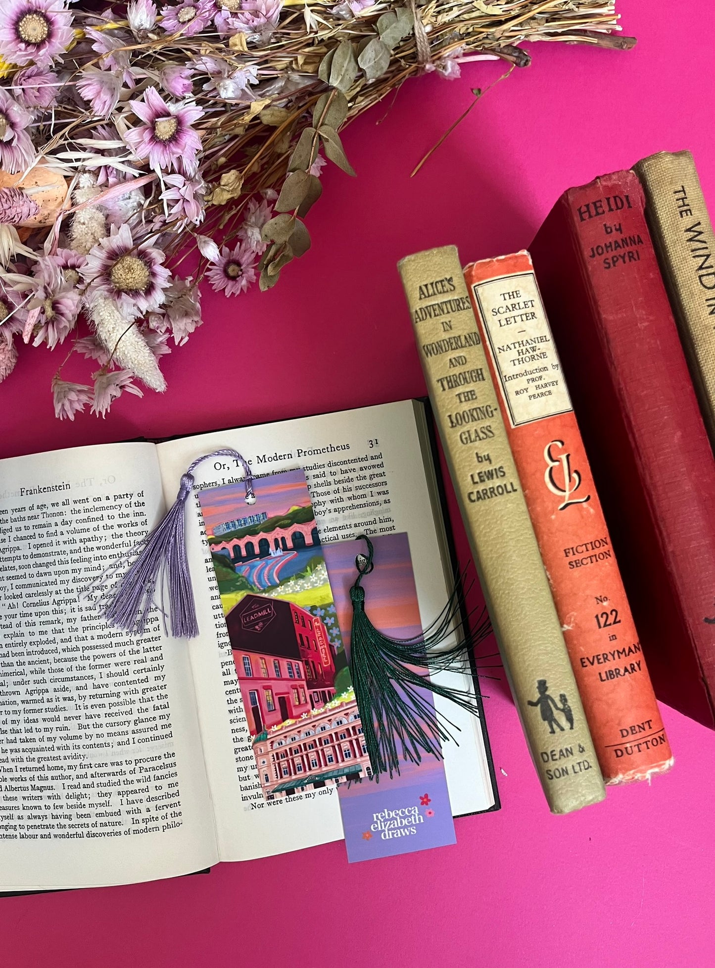 An illustration of Sheffield city on a bookmark. Featuring The Leadmill, the Lyceum, Sheffield train station, Sheffield Park Hill flats, park hill graffiti and water features. This illustration is very vibrant with bright pinks and oranges, the places featured are collaged together against a purple and orange sky. The back features the same purple and orange sky and the Rebecca Elizabeth draws logo. Designed by Rebecca Gibbs at Rebecca Elizabeth Draws.