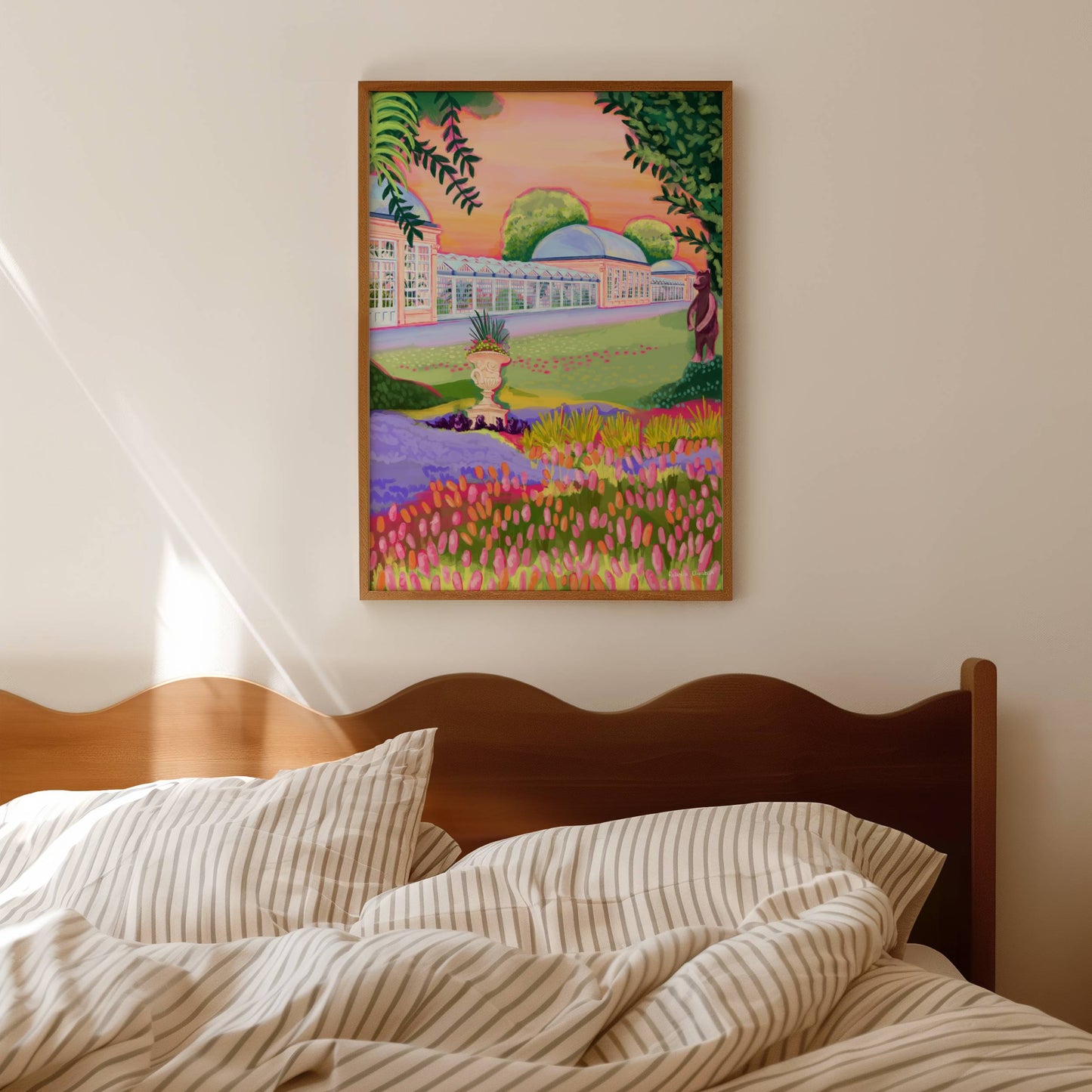 Botanical Gardens in Sheffield Yorkshire. A hand drawn illustration of the glass buildings filled with tropical plants, a field of orange and pink flowers, an orange sky and the bronze bear from the bear pit. Greens, oranges and pink, this illustration is a summery piece that aims to bring joy. A small signature in white the corner. Designed by Rebecca Gibbs at Rebecca Elizabeth Draws.