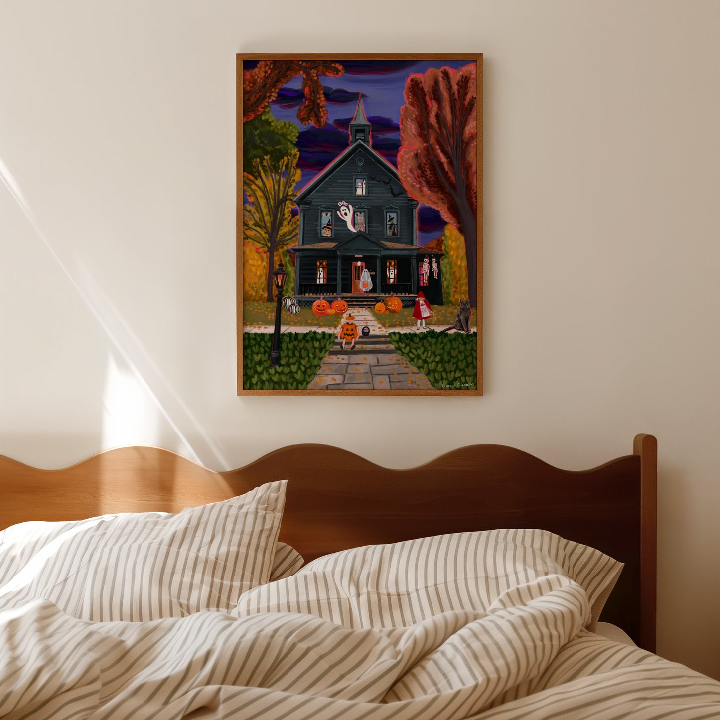Haunted house illustration with ghosts in the windows, witches & a possessed teddy bear. Outside are trick or treaters dressed up as a ghost, pumpkin and little red riding hood ready to collect their sweets. Autumn trees surround the house & fall foliage scatters the ground.