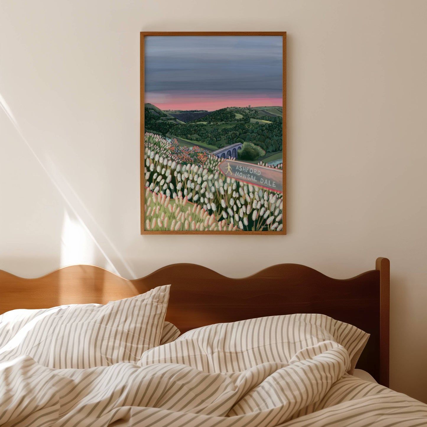 An illustration of Monsal Head in Derbyshire, Peak District. Rolling green hills filled with trees, an old viaduct over the river Wye and white flowers in the foreground. The sky is a setting sun with pink on the horizon fading into dark blue grey.