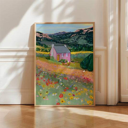 Illustration of a pink house in the mountains in the middle of spring and summer with wildflowers growing all over the surrounding fields in yellow, pink and red.