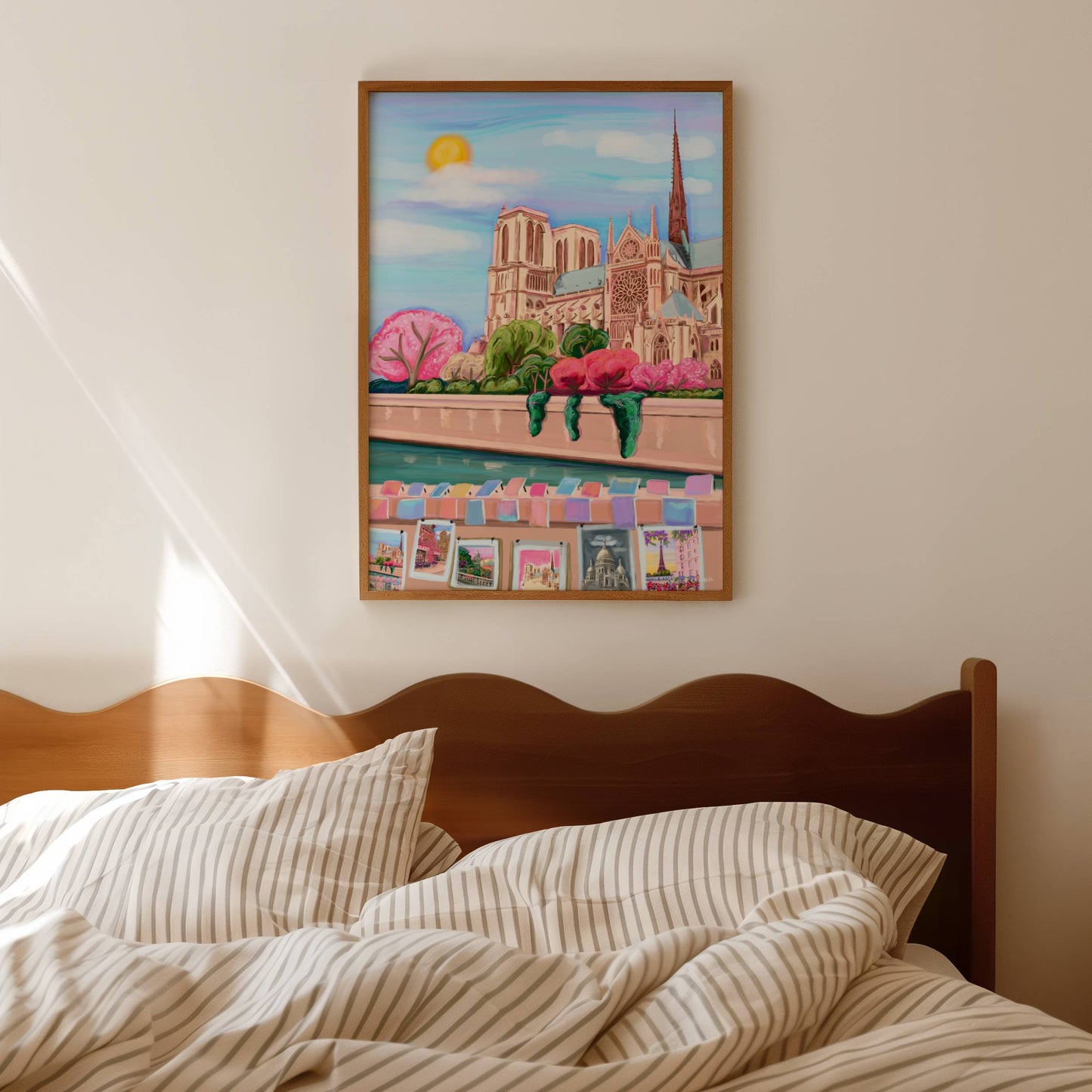 colourful illustration of Notre Dame in Paris, France. With spring pink cherry blossom trees, a sun in the sky and the river seine in front. Along the riverside is small stalls selling art, featuring other Rebecca Elizabeth Draws illustrations.