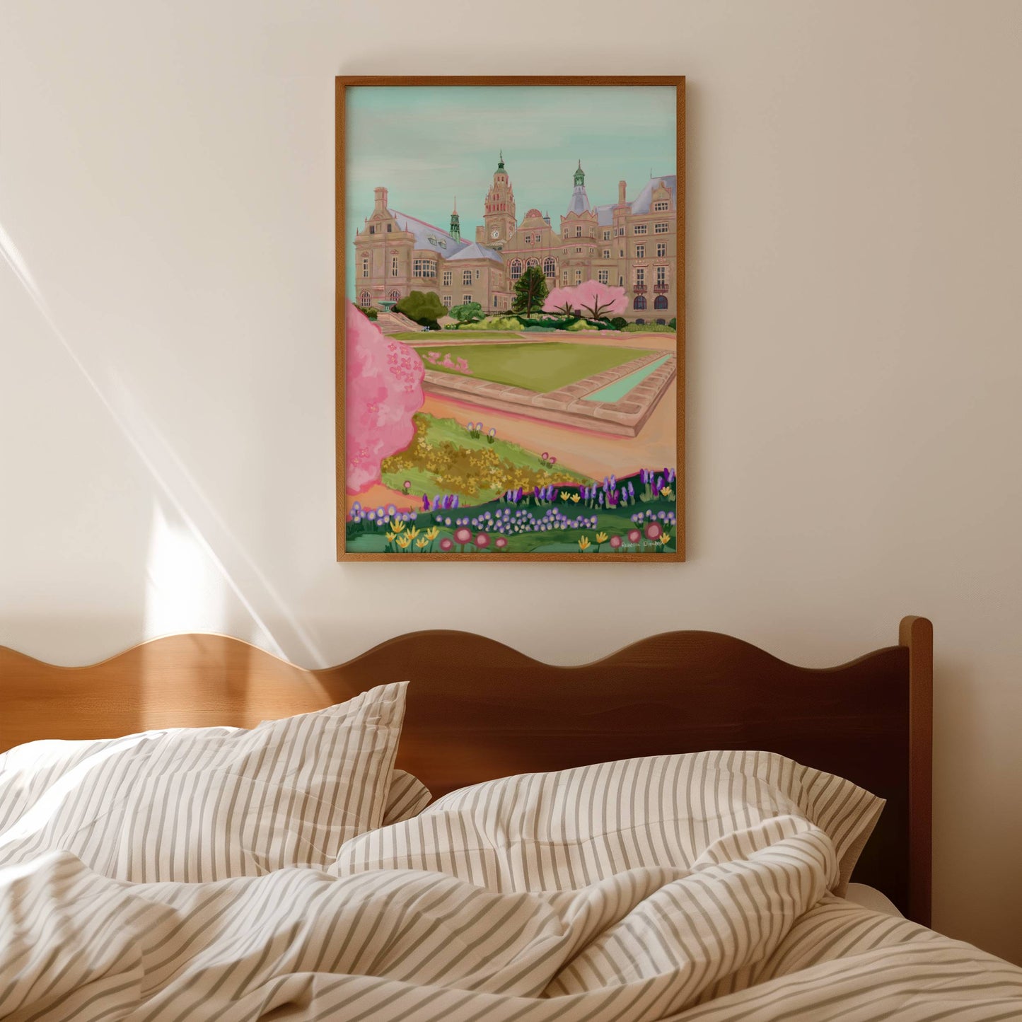 An illustration of the view of the Peace Gardens, Sheffield city centre in springtime. A soft brown building of Sheffield’s town hall with trees in front and pink blossom trees in soft pinks. The foreground features the peace garden with patches of grass amd then flowers in yellows and purples underneath another pink blossom tree in the front and a baby blue sky. There is a small signature in white the corner. Designed by Rebecca Gibbs at Rebecca Elizabeth Draws.