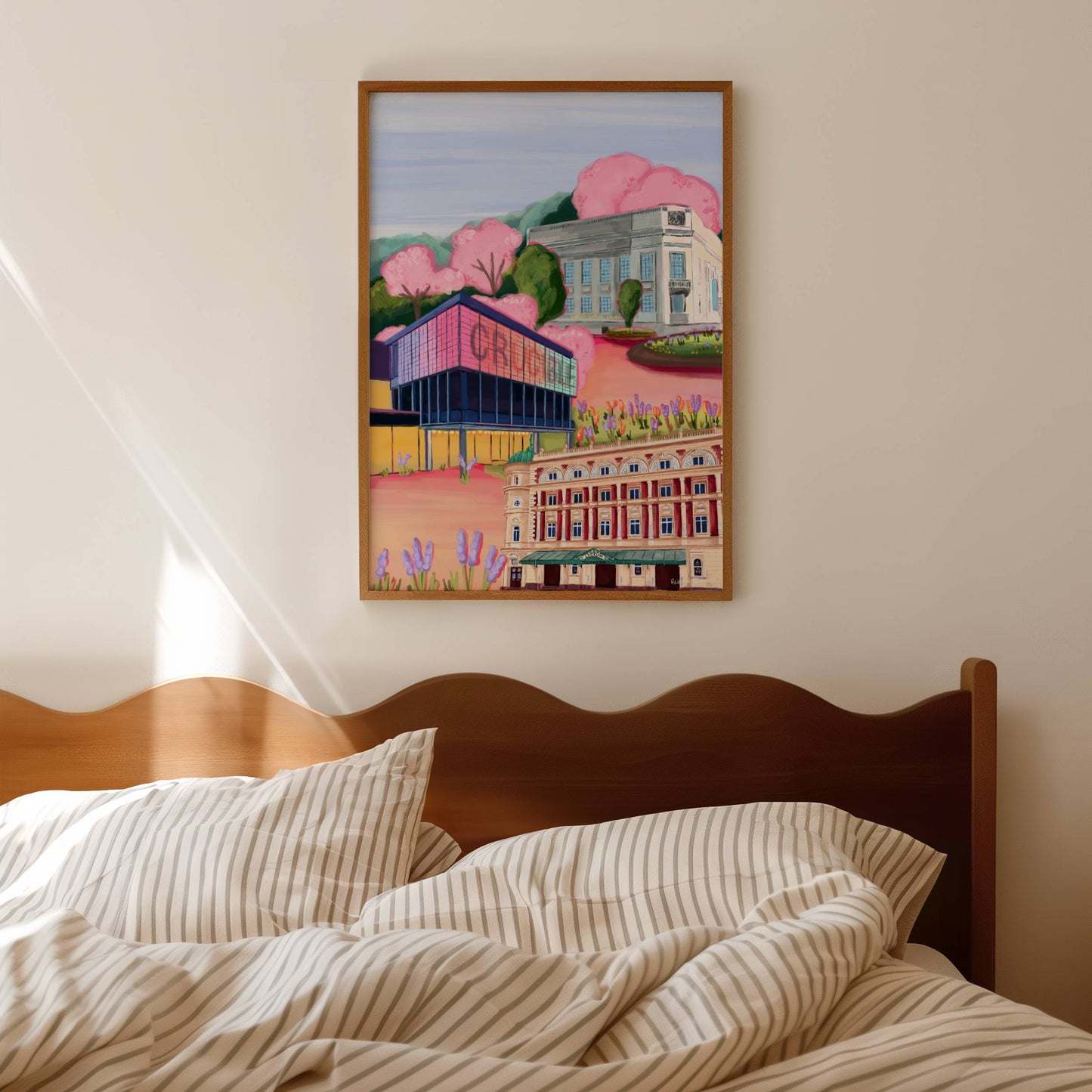 Sheffield theatres illustration, Crucible and Lyceum theatre are illustrated alongside Sheffield library on a background of pink and orange. Trees in both green and pink surround and a baby blue sky.