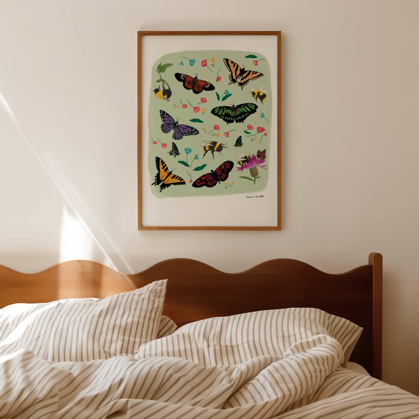 A collection of wildflowers, bumblebees and butterflies hand painted in gouache and edited digitally into a collaged design on a light green background and a small signature underneath. The butterflies are purple, red, cream and green. The flowers are delicate in pinks and blues.