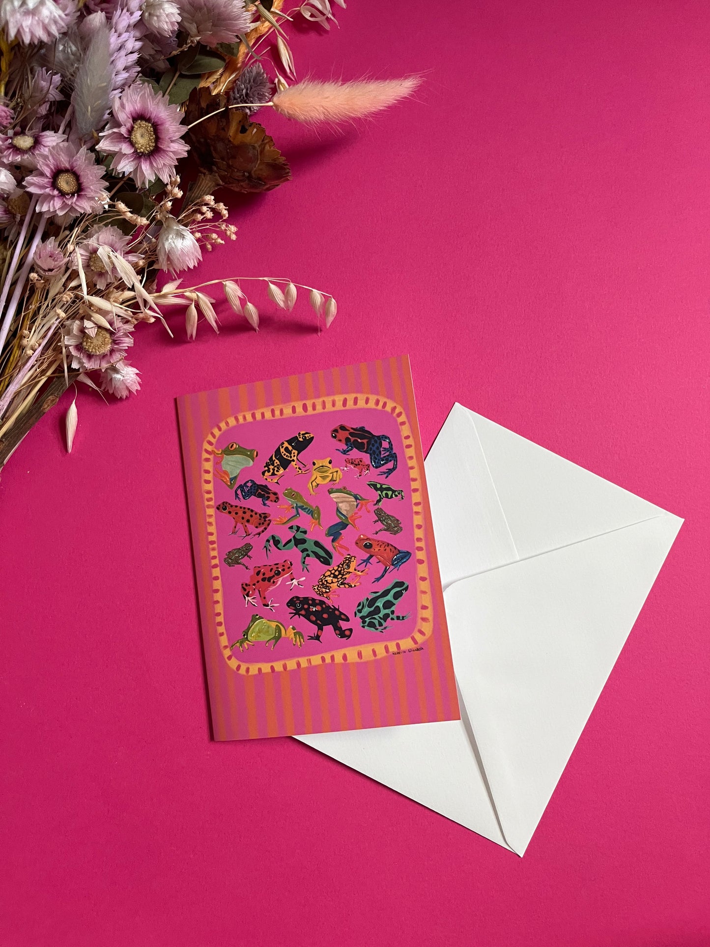 A collection of vibrant froggies to bring a pop of colour to your life. Hand painted rainforest frogs in gouache and edited digitally into a collaged design on a vibrant pink & red background. The back of the card has the Rebecca Elizabeth Draws logo