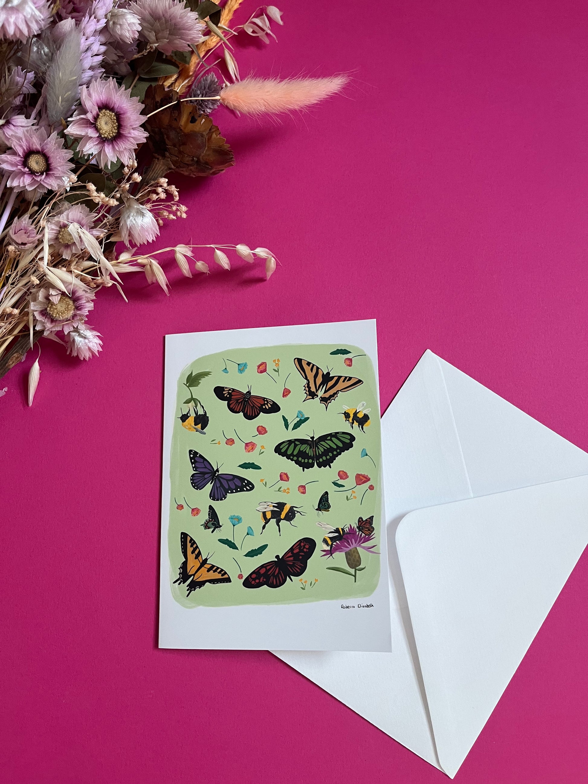 A collection of wildflowers, bumblebees and butterflies hand painted in gouache and edited digitally into a collaged design on a light green background. With a green back and the Rebecca Elizabeth Draws logo.  