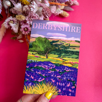 Postcard of Derbyshire with a colorful landscape illustration on a pink background.