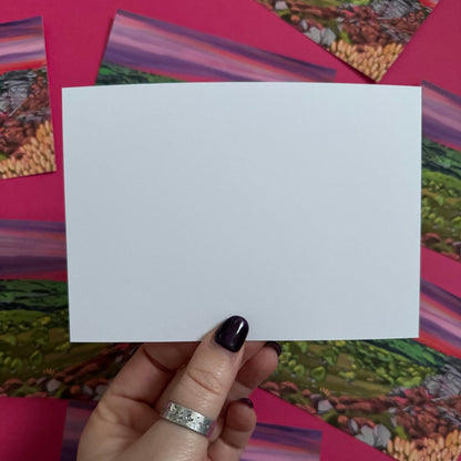 A colourful illustration of Curbar edge, Derbyshire with the rock formation to the right covered in pink and golden flowers, yellow flowers in the foreground and then rolling hills to the left with lots of greenery and trees. A stunning bright pink and purple sunset across the sky.  Designed by 
Rebecca Elizabeth draws. 