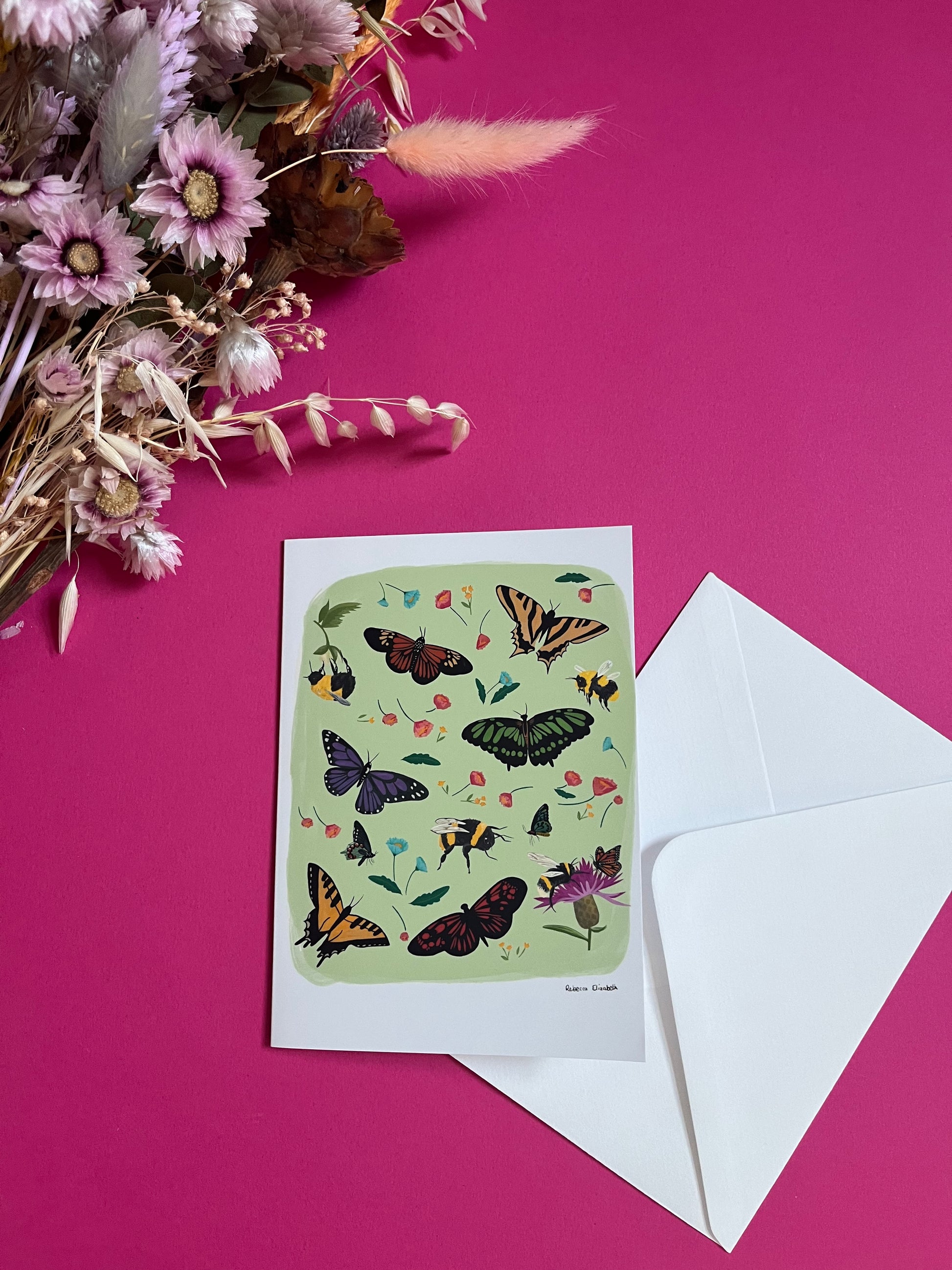 A collection of wildflowers, bumblebees and butterflies hand painted in gouache and edited digitally into a collaged design on a light green background. With a green back and the Rebecca Elizabeth Draws logo.  