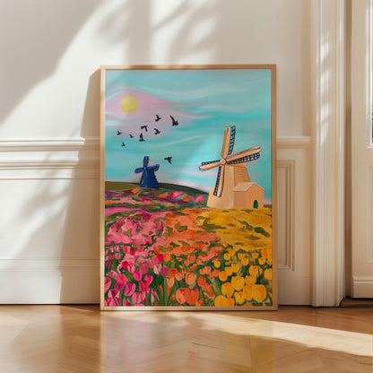 An illustration of the tulip fields in Amsterdam, The Netherlands. Tulip fields in yellow, orange & pink leading back to more field full of coloured flowers and a cream and blue windmill. The sky is a soft blue with bird silhouettes and a yellow sun. There is a small signature in white the corner.  Designed by Rebecca Gibbs at Rebecca Elizabeth Draws.