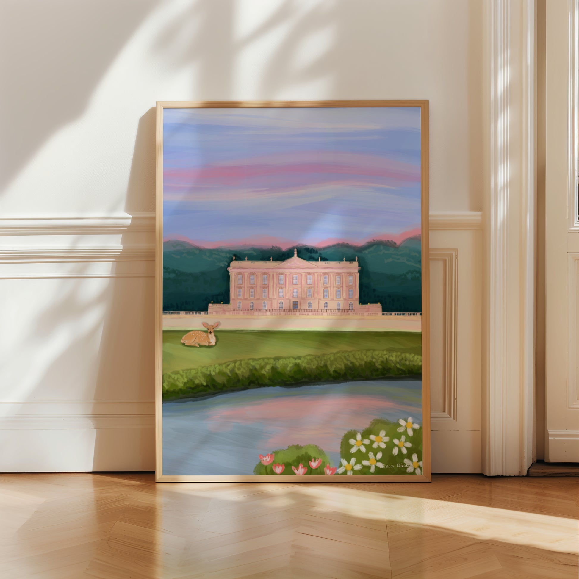 An illustration of Chatsworth house, a stately home found in the Derbyshire Dales. The house is a soft pink surrounded by green trees and fields, a river runs along the front and a deer rests in the foreground. The sky is a soft blue and pink hue, the colours of a beautiful sunset. A small signature in white the corner.  Designed by Rebecca Gibbs at Rebecca Elizabeth Draws.