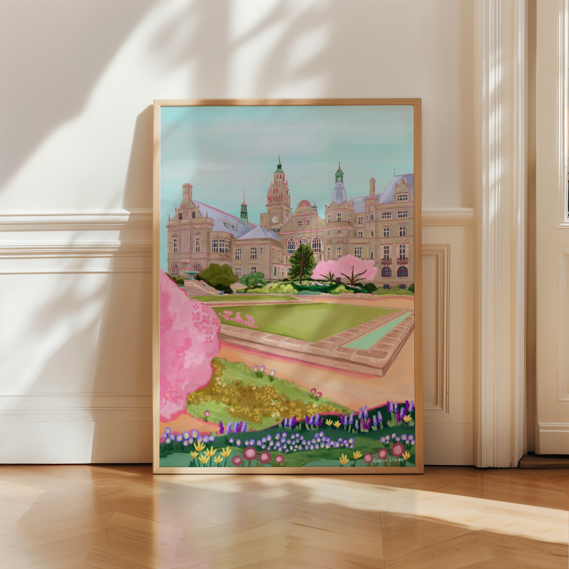 An illustration of the view of the Peace Gardens, Sheffield city centre in springtime. A soft brown building of Sheffield’s town hall with trees in front and pink blossom trees in soft pinks. The foreground features the peace garden with patches of grass amd then flowers in yellows and purples underneath another pink blossom tree in the front and a baby blue sky. There is a small signature in white the corner.  Designed by Rebecca Gibbs at Rebecca Elizabeth Draws.