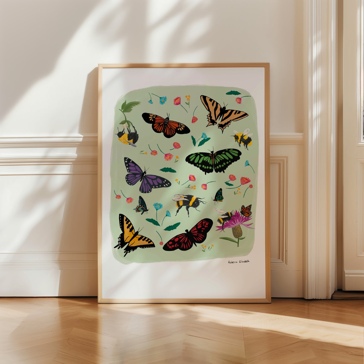 A collection of wildflowers, bumblebees and butterflies hand painted in gouache and edited digitally into a collaged design on a light green background and a small signature underneath. The butterflies are purple, red, cream and green. The flowers are delicate in pinks and blues. 