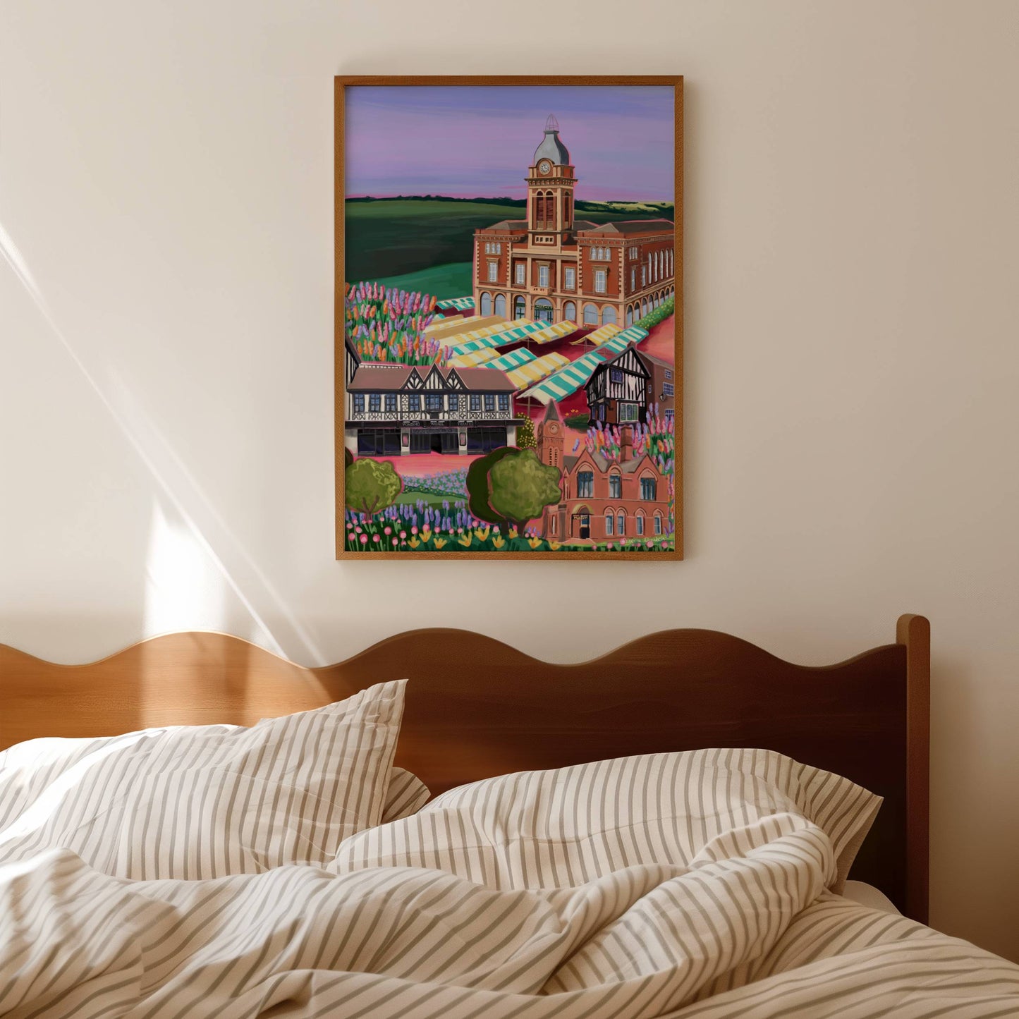 Chesterfield market town in Derbyshire illustration. A colourful market hall, winding wheel theatre, museum & towns oldest pub the royal oak are all illustrated with pink highlights whilst staying true to their authentic colours. The foreground is full of flowers, & the buildings lay against fields of green & a purple sky. 