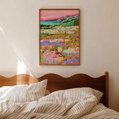 Colourful Illustration of wildflower fields with a picnic blanket, a basket of daisies and a few nibbles. In the background you can find the distant mountains and a lake where 2 swans sit. Designed by Rebecca Elizabeth Draws. 