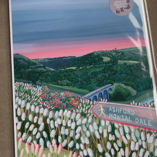 An illustration of Monsal Head in Derbyshire, Peak District. Rolling green hills filled with trees, an old viaduct over the river Wye and white flowers in the foreground. The sky is a setting sun with pink on the horizon fading into dark blue grey. 