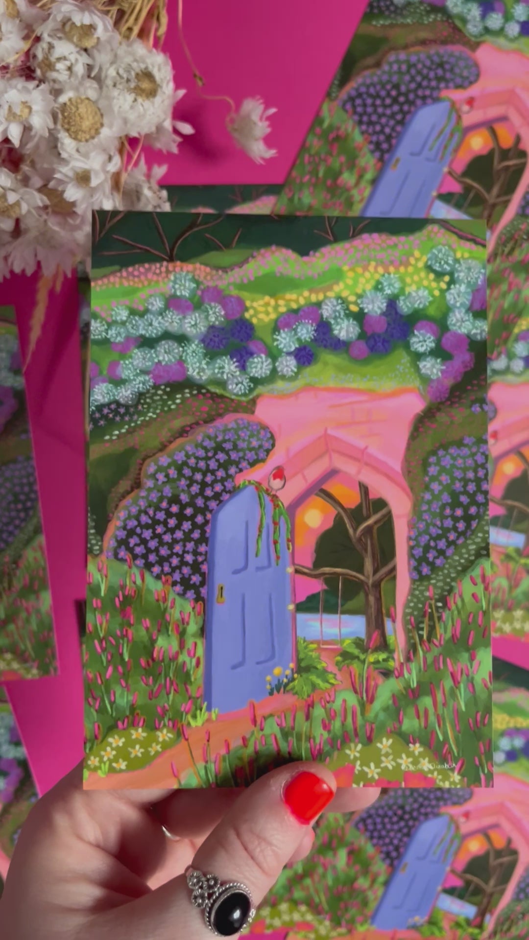 video of Postcard art inspired by the children’s book The Secret Garden with a door leading to a hidden paradise. A swing over the pond, a setting sun and the foreground outside is engulfed in wildflowers. There is a robin perched on the door. Designed by Rebecca Elizabeth Draws. 