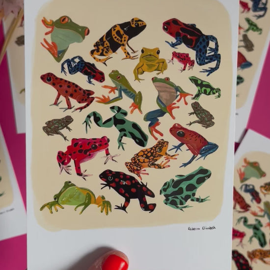 video of Postcard of colourful frog illustrations in red, yellow, blue, green and brown set against a cream background with a small black signature at the bottom right. Designed by Rebecca Elizabeth Draws. 