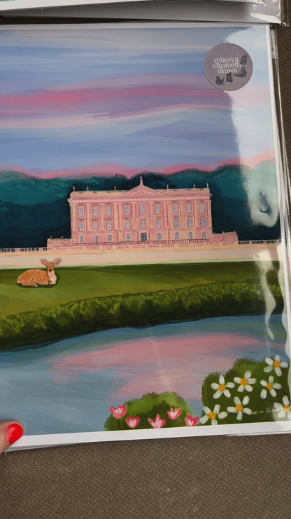 An illustration of Chatsworth house, a stately home found in the Derbyshire Dales. The house is a soft pink surrounded by green trees and fields, a river runs along the front and a deer rests in the foreground. The sky is a soft blue and pink hue, the colours of a beautiful sunset. A small signature in white the corner.  Designed by Rebecca Gibbs at Rebecca Elizabeth Draws.