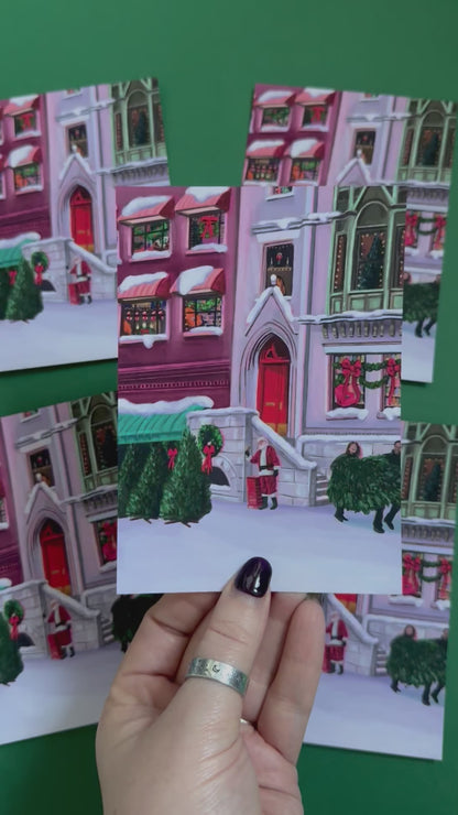 Christmas Illustrated postcard inspired by the film When Harry Met Sally. With Harry & Sally running off with their Christmas tree at the right hand side, the tree shop to the left and a background of new York buildings with Christmas décor peaking out the windows. Designed by Rebecca Gibbs at Rebecca Elizabeth Draws.