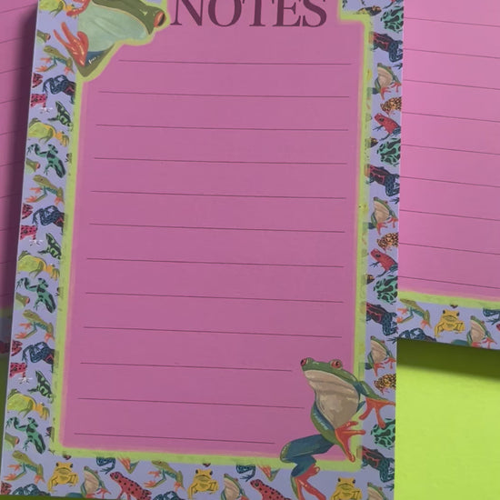 frog pattern notepad with purple background and a pink notes section. A couple of prominent frog’s peer around the notes. There is an accent colour of green, designed by Rebecca Elizabeth Draws.