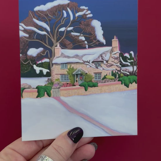 Christmas Illustration of the classic Rosehill cottage from the movie The holiday staring Kate Winslet and Cameron Diaz. Set amongst the English countryside with landscapes of wintery fields, a classic cosy Christmas cottage. Christmas card with pink back designed by Rebecca Gibbs at Rebecca Elizabeth Draws.