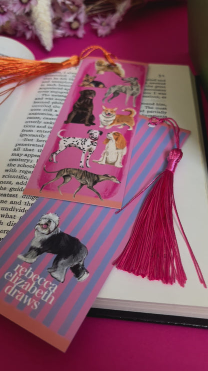 Hand drawn illustration of dogs, from whippets, lurchers, Labradors, Yorkshire terriers & more. All drawn in a collection on a pink background with pink and purple stripes on a bookmark with a pink & purple background & the Rebecca Elizabeth Draws logo. 