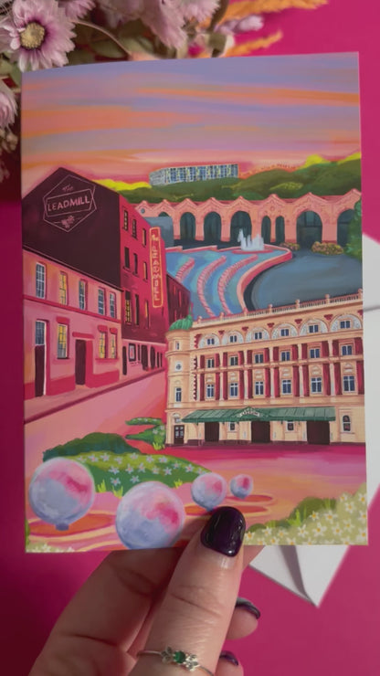 An illustrated greeting card of Sheffield city, Yorkshire. Featuring The Leadmill, the Lyceum, Sheffield train station, Sheffield Park Hill flats, park hill graffiti and water features. This illustration is very vibrant with bright pinks and oranges, the places featured are collaged together against a purple and orange sky. There is a small signature in white the corner.  Designed by Rebecca Gibbs at Rebecca Elizabeth Draws.