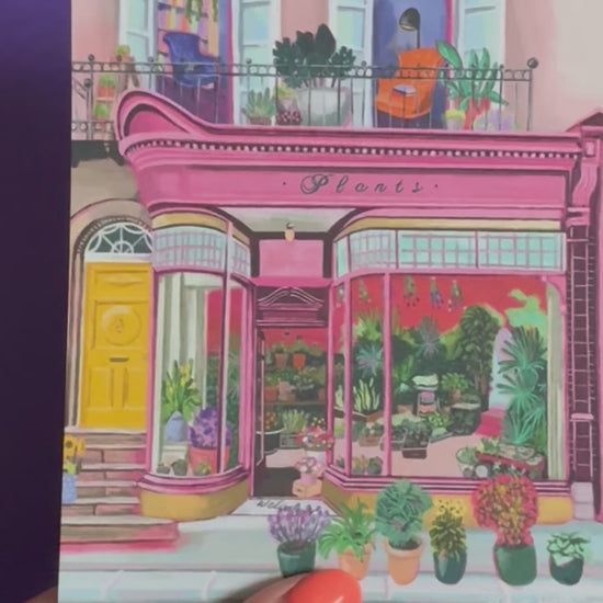 Pink shop front of a plant store with lots of greenery inside, a balcony above with windows showing chairs and a bookcase and more flowers. A yellow door to the side with a sunflower vase resting on the steps by Rebecca Elizabeth Draws. 