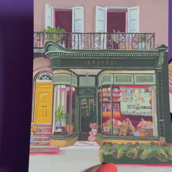 A colourful illustration of a craft shop with the store front in green and looking through the window and at all the goodies. Sewing, drawing, painting, we have it all here at the craft shop. Designed by Rebecca Elizabeth draws. 