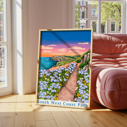 Framed artwork of a scenic path with flowers in a room with large windows and a red sofa.